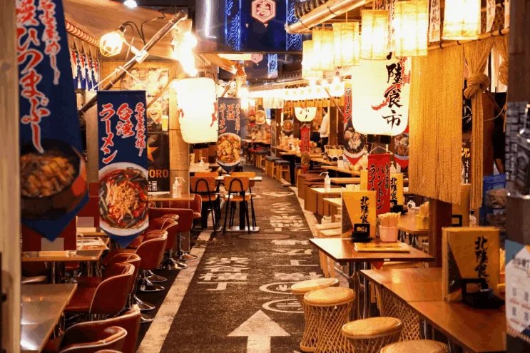 看板と提灯が並ぶ屋内の横丁