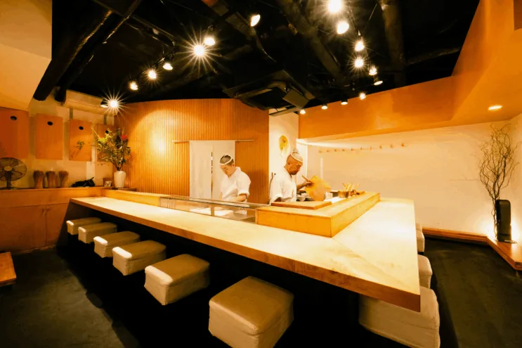 明るい木のカウンターがある寿司店